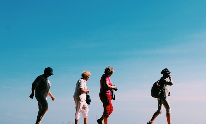 Two active adult friends walking together at a 55+ community